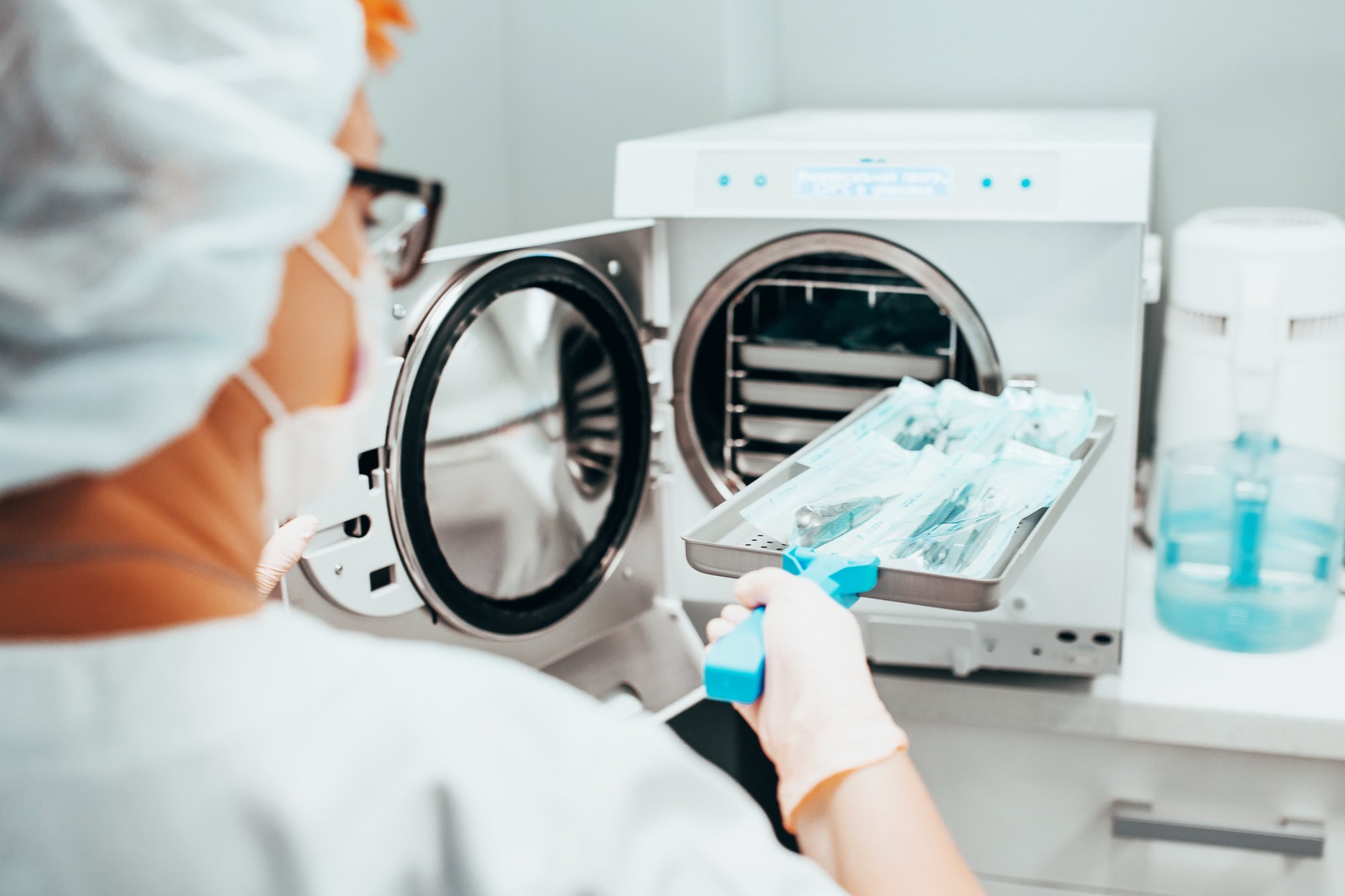 Sterilization of medical instruments - a nurse loads a tray into an autoclave stock photo