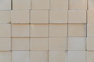 Stacked furnace bricks used for lining an industrial kiln in high-temperature applications.