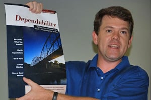 man holding up poster that reads "dependability"